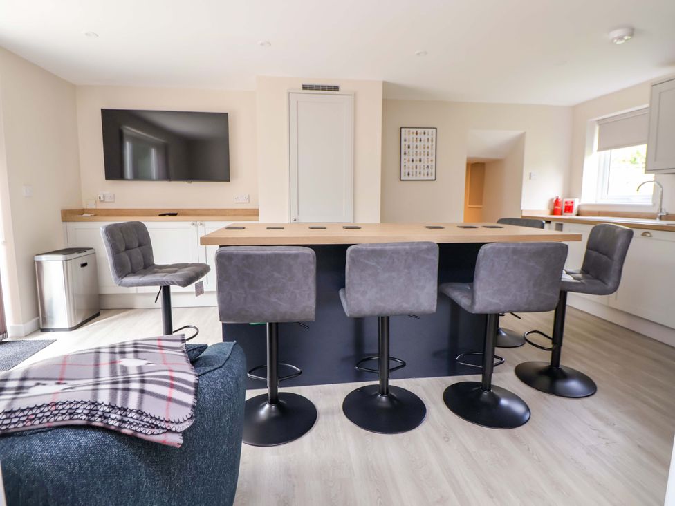 A kitchen with a large island and bar stools at Cartref Pen Y Ball near Holywell