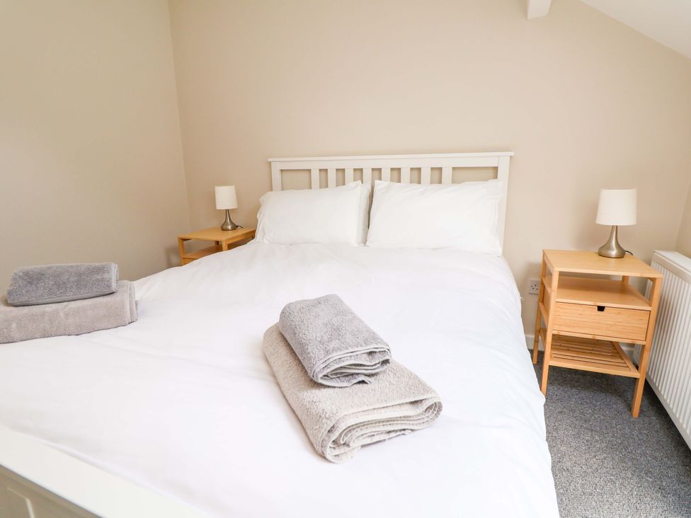 A bedroom with a double bed and towels on the bed at Cartref Pen Y Ball near Holywell