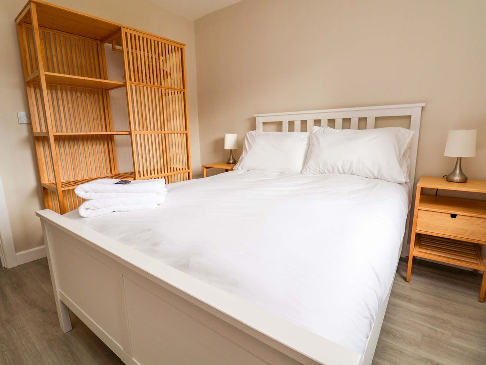 A bedroom with a bed and shelves at Cartref Pen Y Ball near Holywell