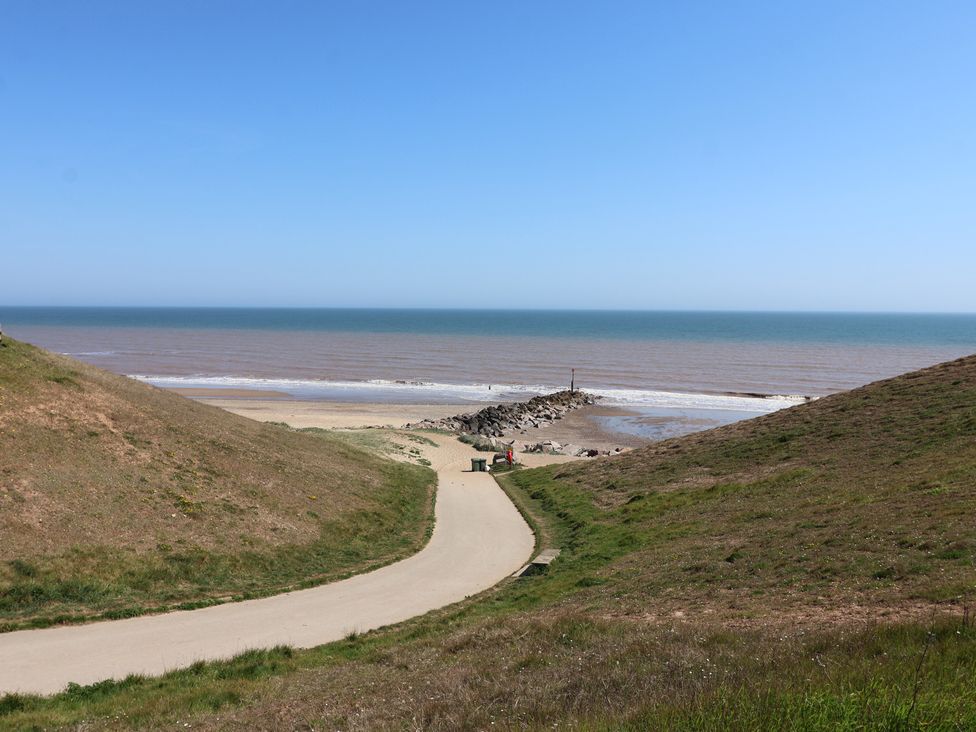 A beach view with a pathway leading to the sea at The Old Vicarage Annex Hornsea
