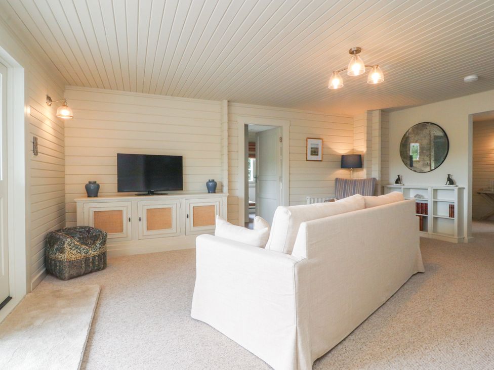 A living room with a television and sofa at Manor Lodge in Clitheroe