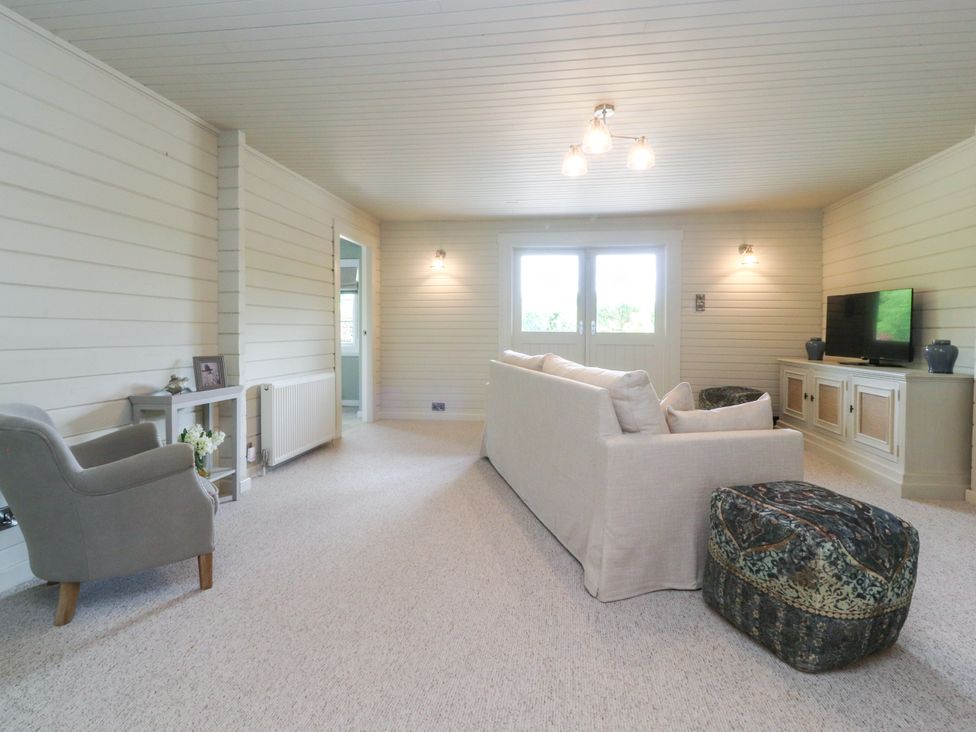 A living room with a sofa and TV at Manor Lodge in Clitheroe