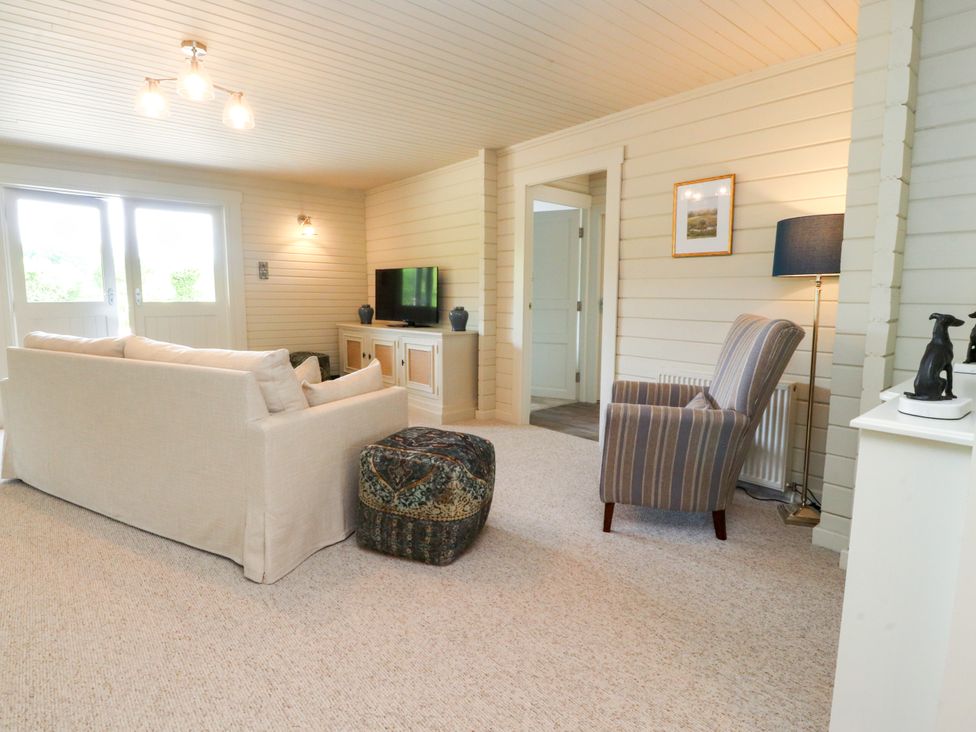 A living room with a sofa and television at Manor Lodge in Clitheroe