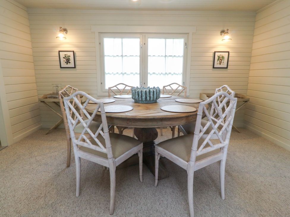 A dining room with a wooden table and chairs at Manor Lodge in Clitheroe