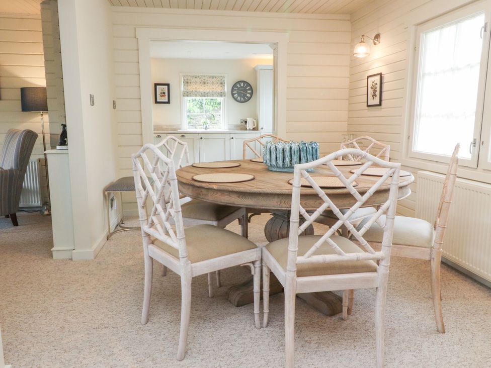 A dining room with a round table and chairs at Manor Lodge in Clitheroe