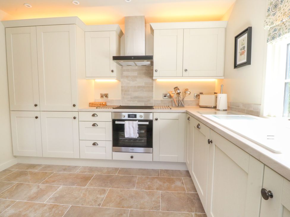A kitchen with cabinets and appliances at Manor Lodge in Clitheroe