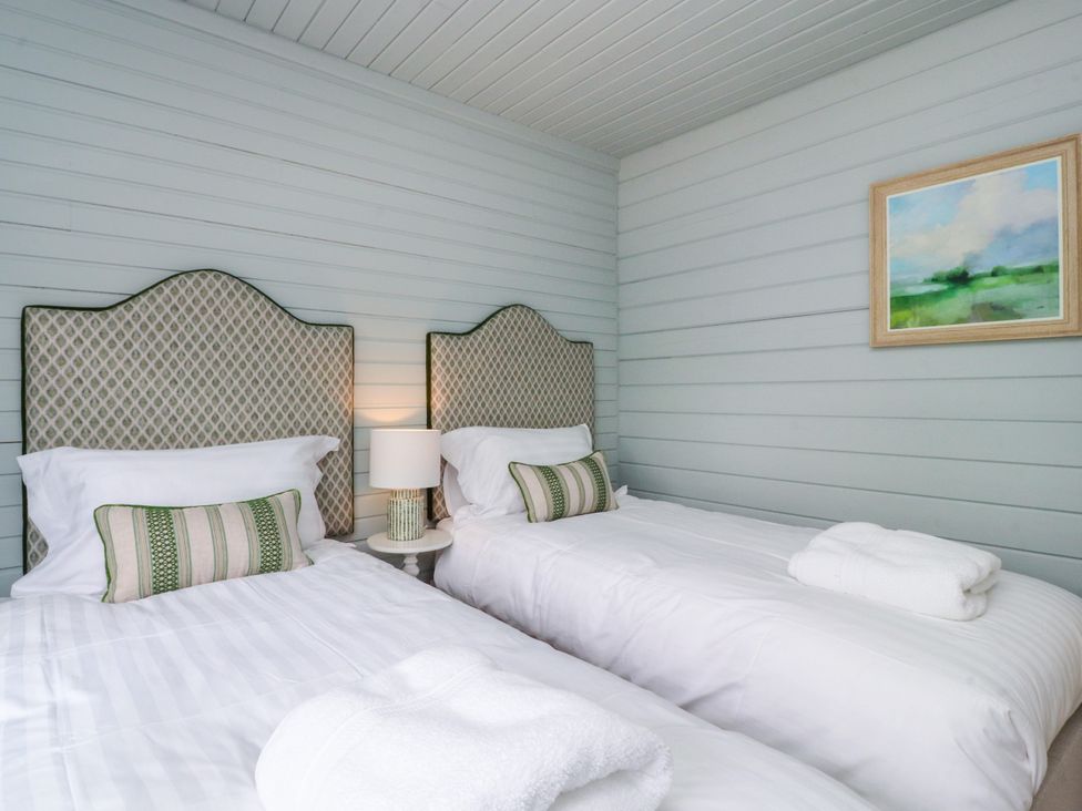 A bedroom with two beds and a lamp at Manor Lodge in Clitheroe