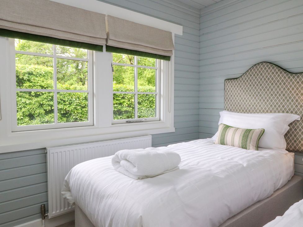 A bedroom with two single beds and windows at Manor Lodge Clitheroe