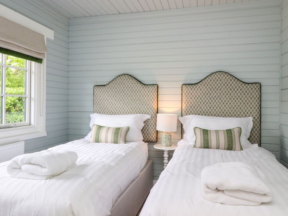 A bedroom with two single beds and a window at Manor Lodge Clitheroe