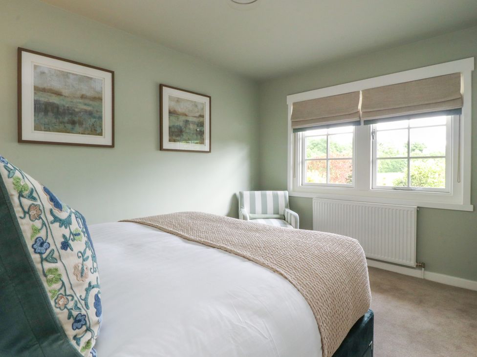 A bedroom with a bed and chair at Manor Lodge in Clitheroe