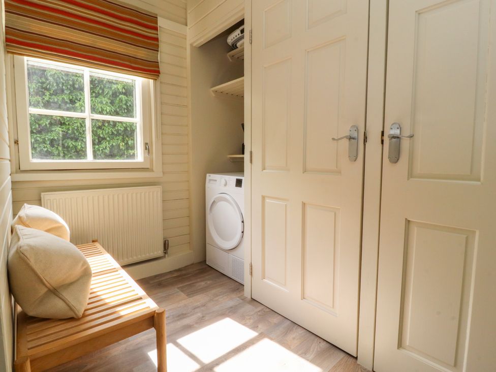 A utility room with a washing machine and bench at Manor Lodge in Clitheroe