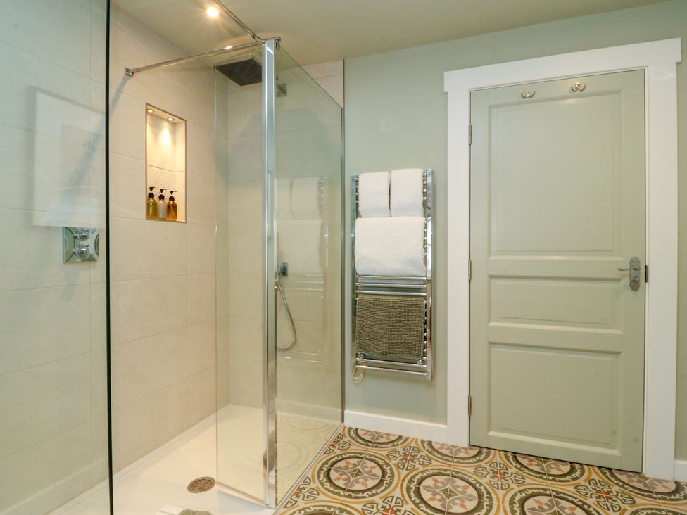 A bathroom with a shower and towels at Manor Lodge in Clitheroe
