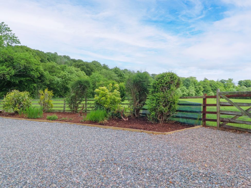 A garden with gravel, bushes, and a fence at Manor Lodge in Clitheroe