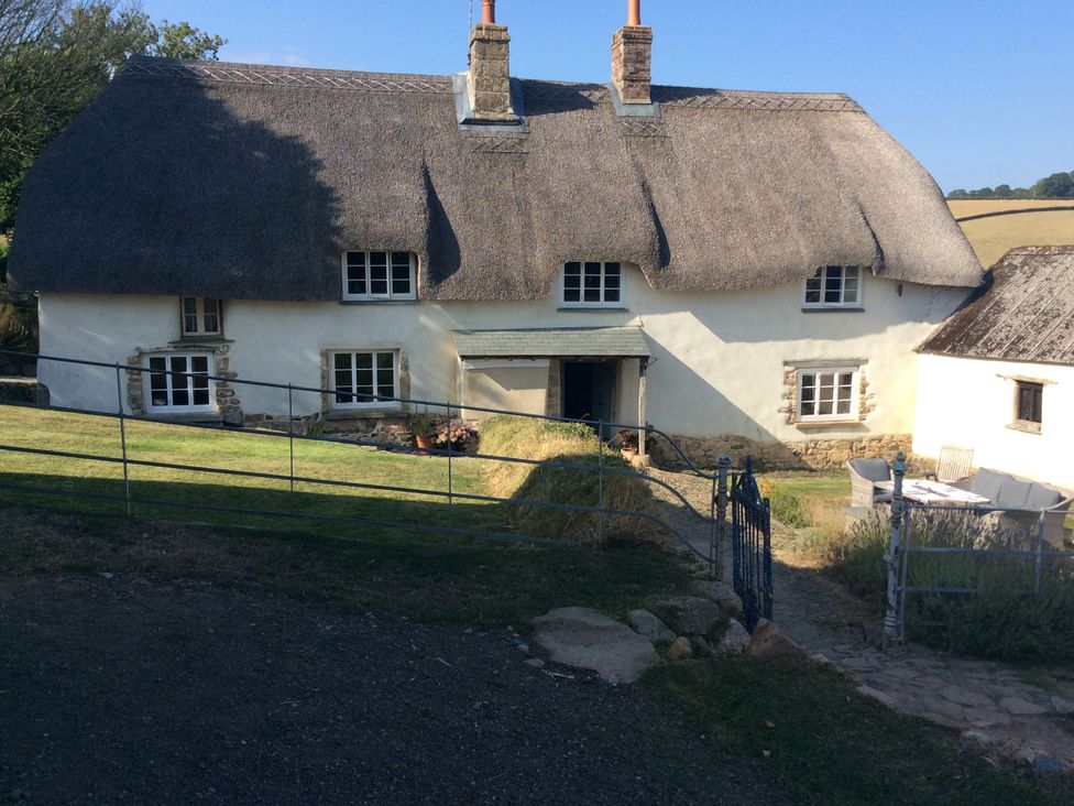 A thatched house with a garden and a gate at Westacombe Farm in Dunsford near Tedburn St Mary