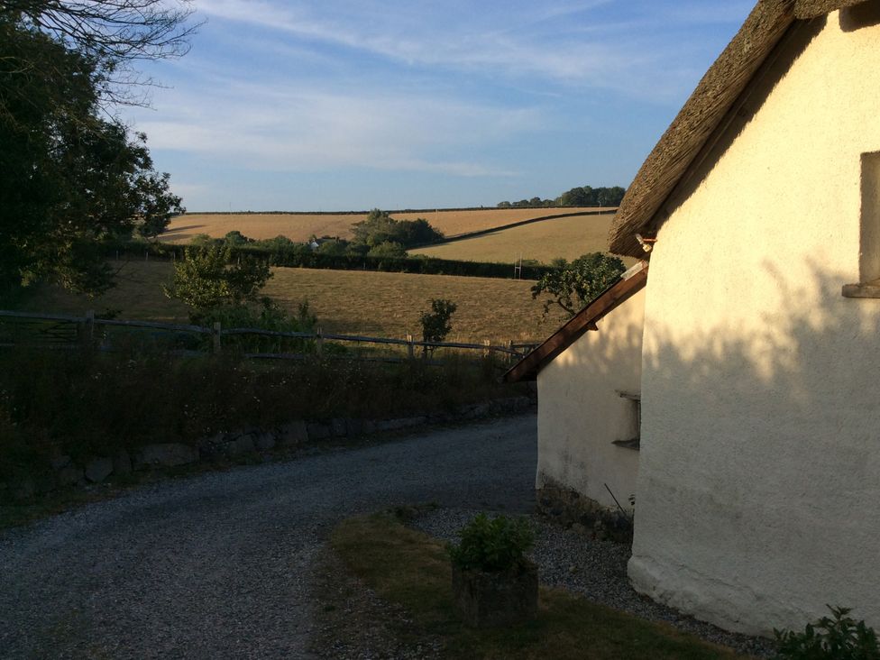An outdoor view of a field and house at Westacombe Farm in Dunsford near Tedburn St Mary