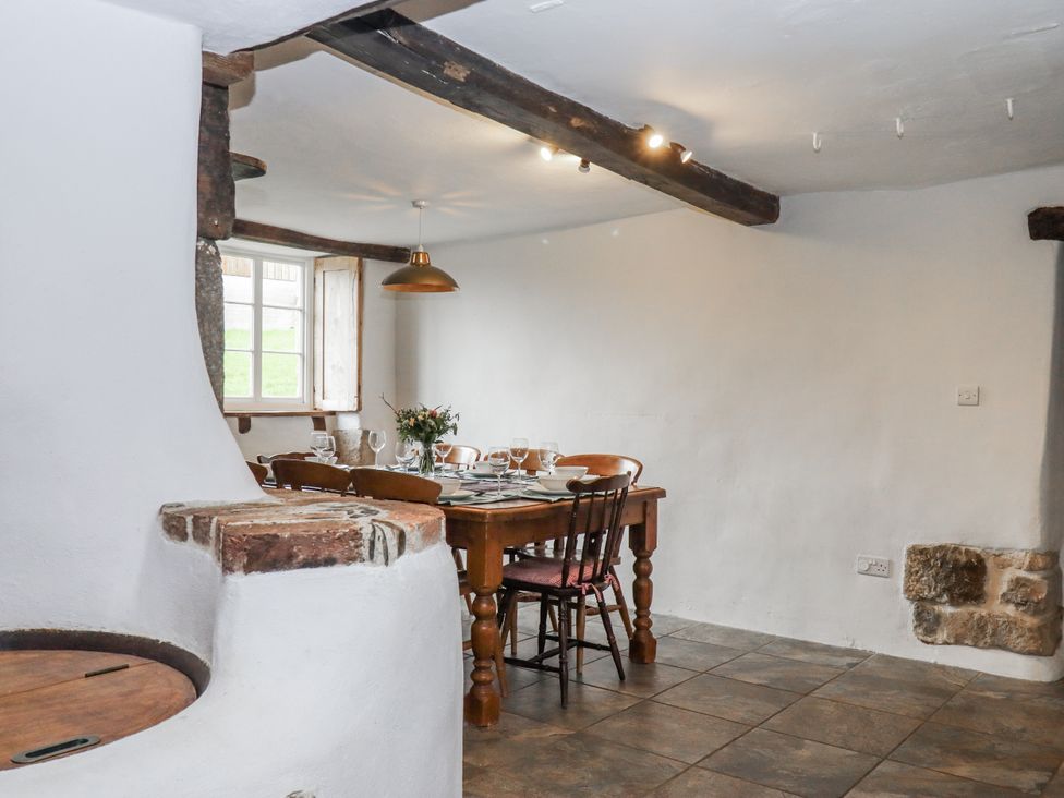 A dining room with a table and chairs at Westacombe Farm in Dunsford