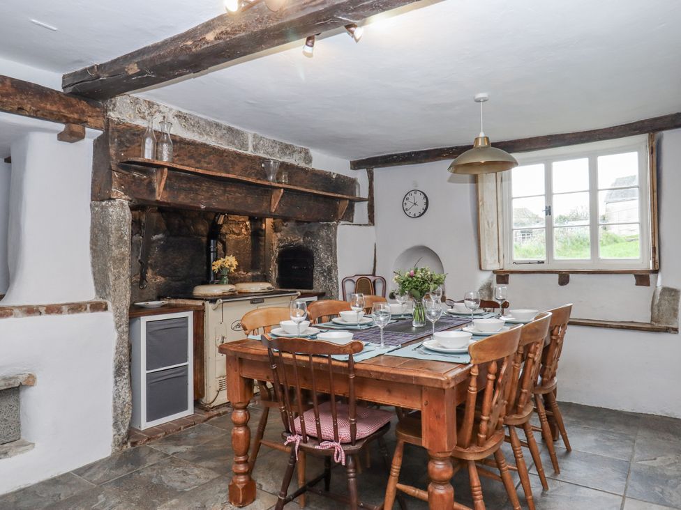 A dining room with a wooden table and chairs at Westacombe Farm Dunsford