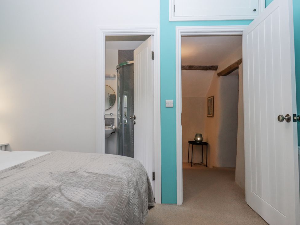 A bedroom with a bed and an adjoining bathroom at Westacombe Farm in Dunsford