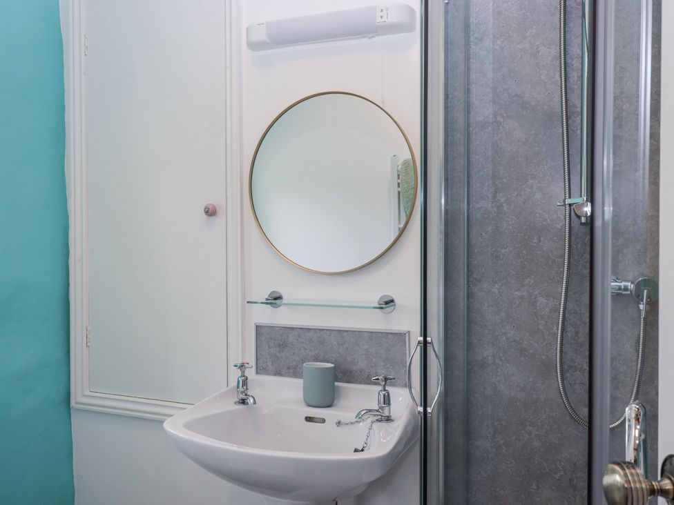 A bathroom with a sink, mirror, and shower at Westacombe Farm in Dunsford