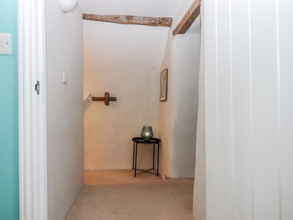 A hallway with a table and vase at Westacombe Farm in Dunsford