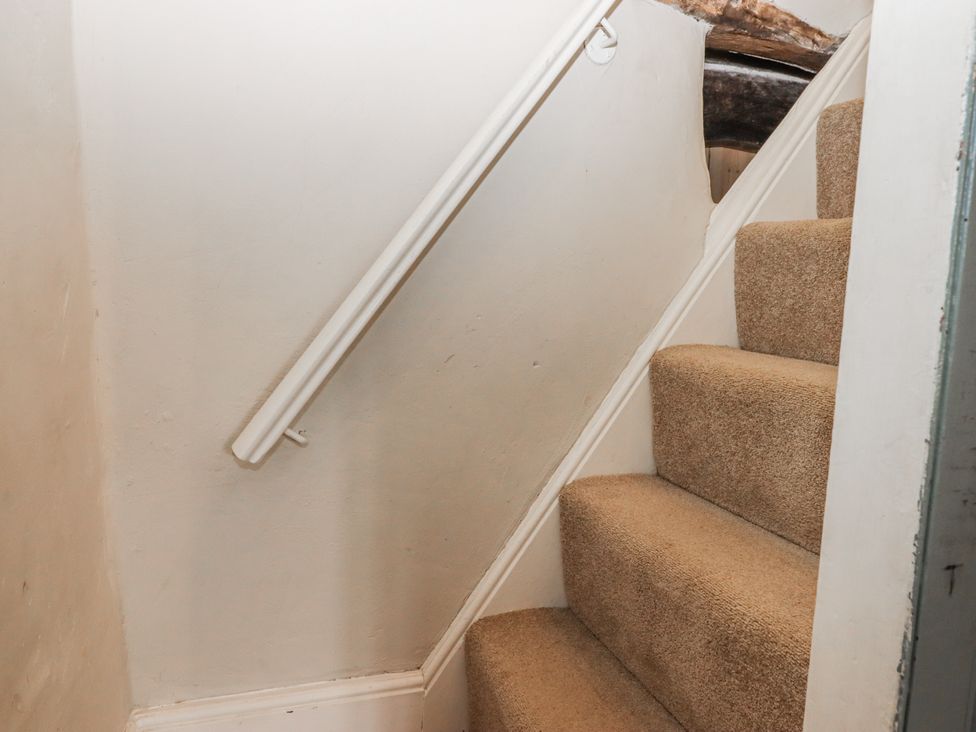 A staircase with a carpet and handrail at Westacombe Farm Dunsford