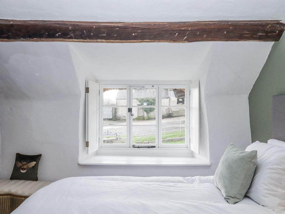 A bedroom with a bed and window at Westacombe Farm in Dunsford