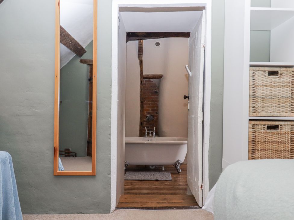 A bathroom with a bathtub and mirror at Westacombe Farm in Dunsford