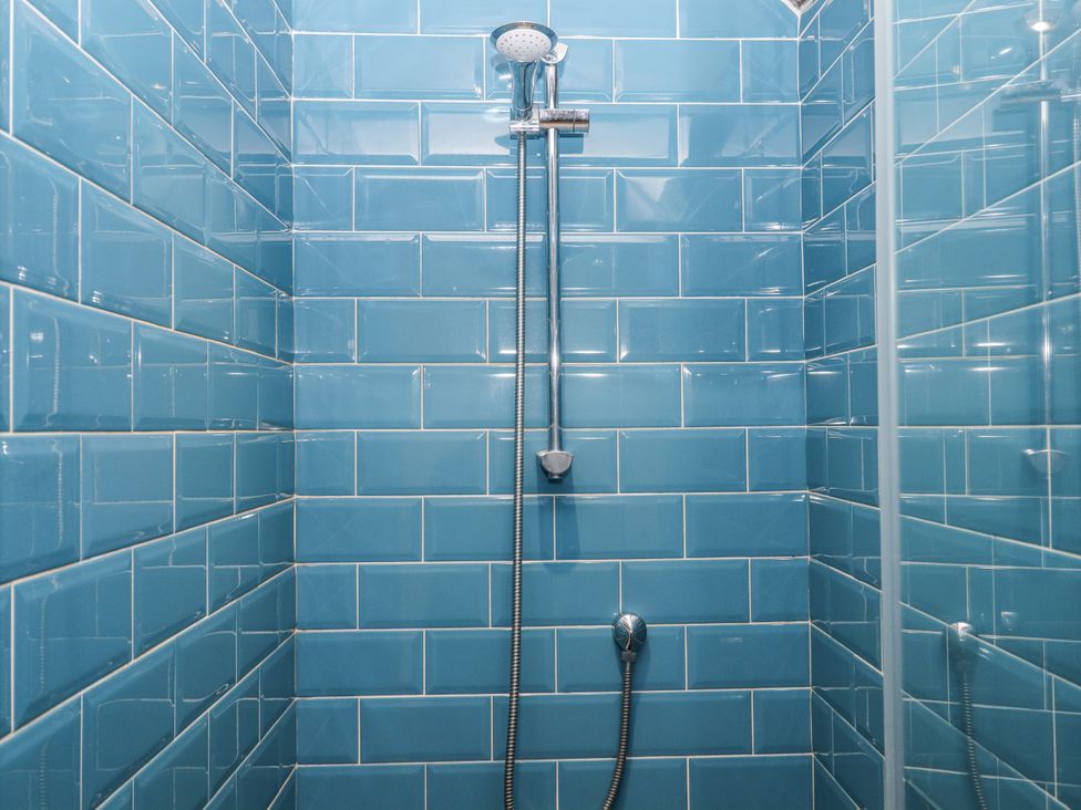 A shower with blue tiles and chrome fixtures at Westacombe Farm in Dunsford