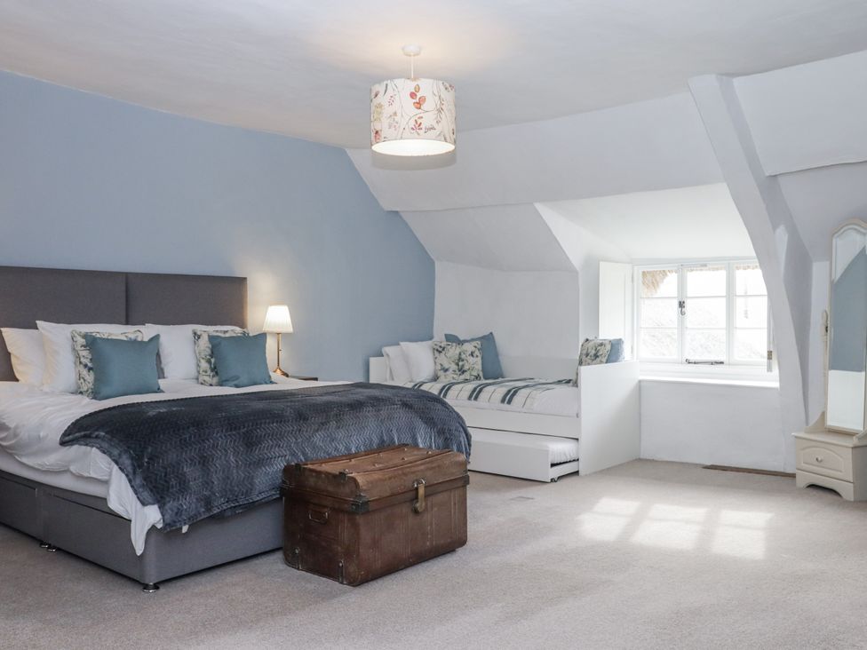 A bedroom with a bed and window seat at Westacombe Farm in Dunsford