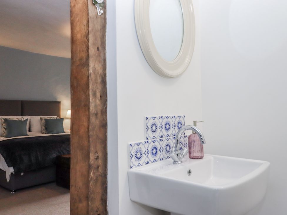 A bathroom with wash basin and mirror visible at Westacombe Farm Dunsford