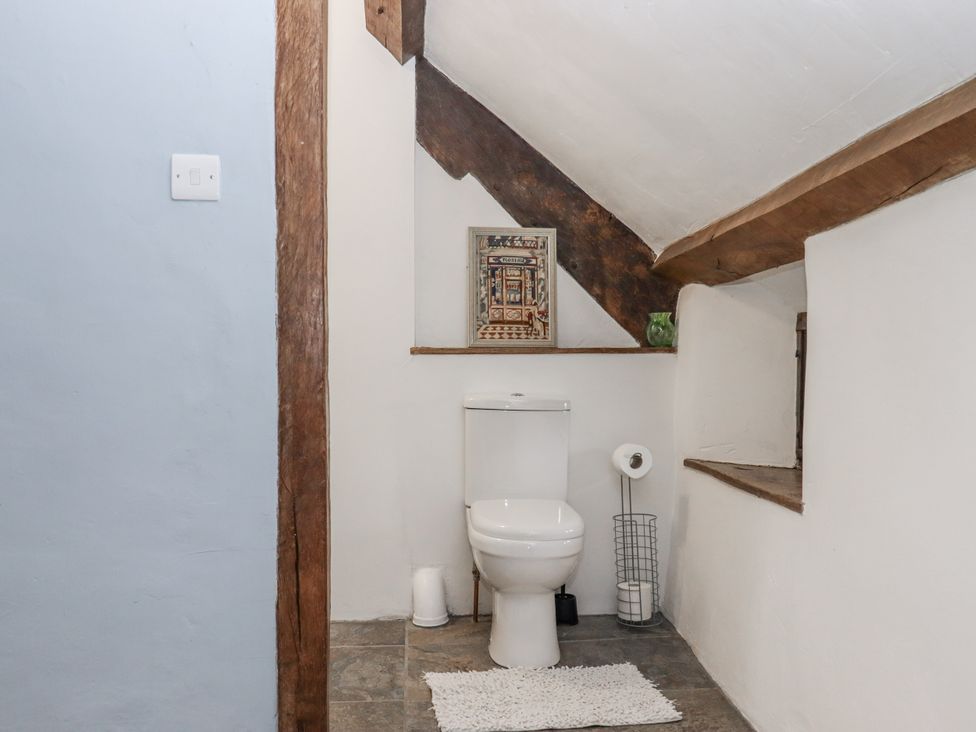 A bathroom with a toilet and shelf at Westacombe Farm in Dunsford