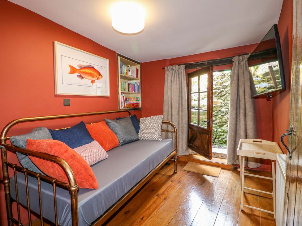A snug with a daybed and bookshelf at Chimney Cottage in Winster