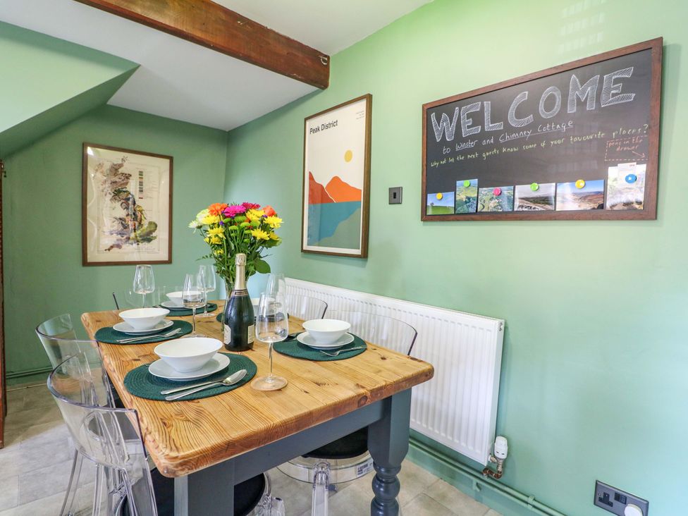 A dining room with a table set for a meal at Chimney Cottage in Winster