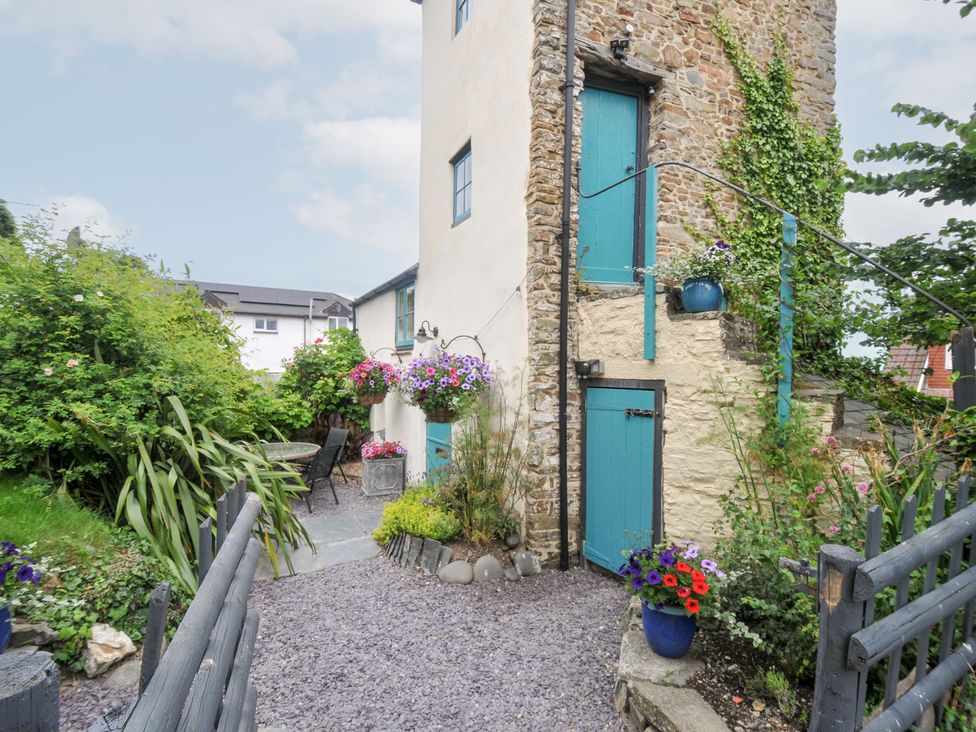 A garden with flowers, a table, and chairs at Tadworthy Tower in Northam