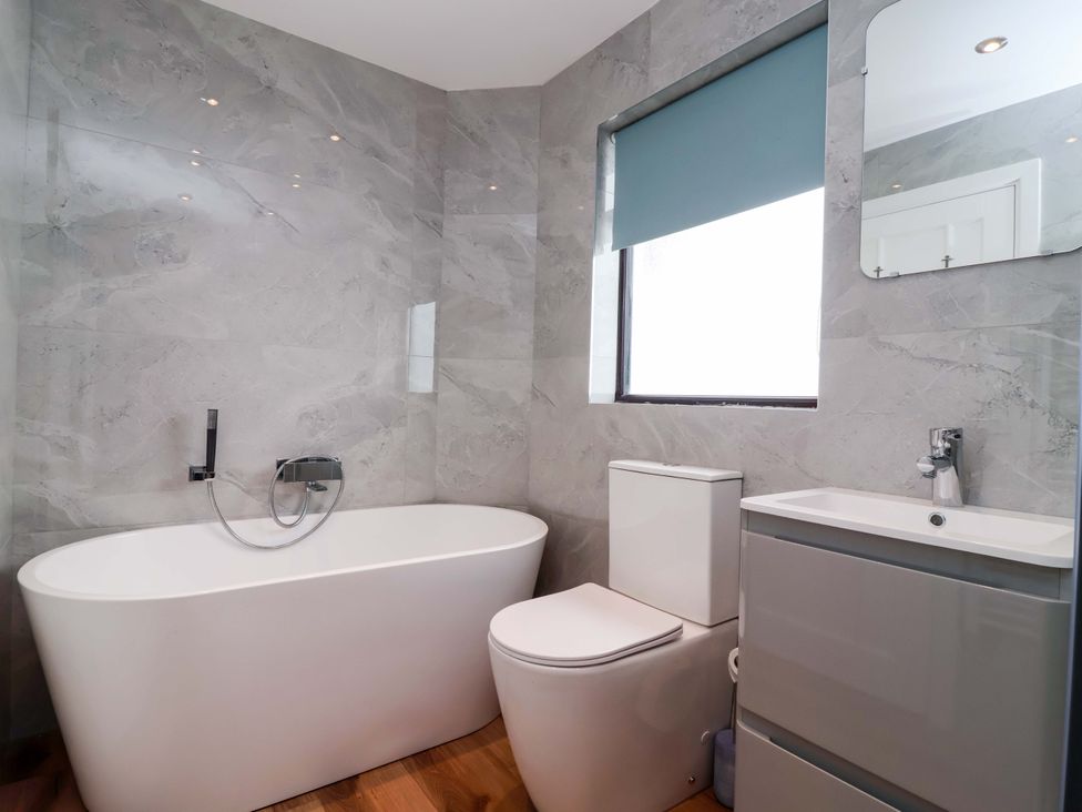 A bathroom with a bathtub, toilet, and sink at Kernyk in Camelford