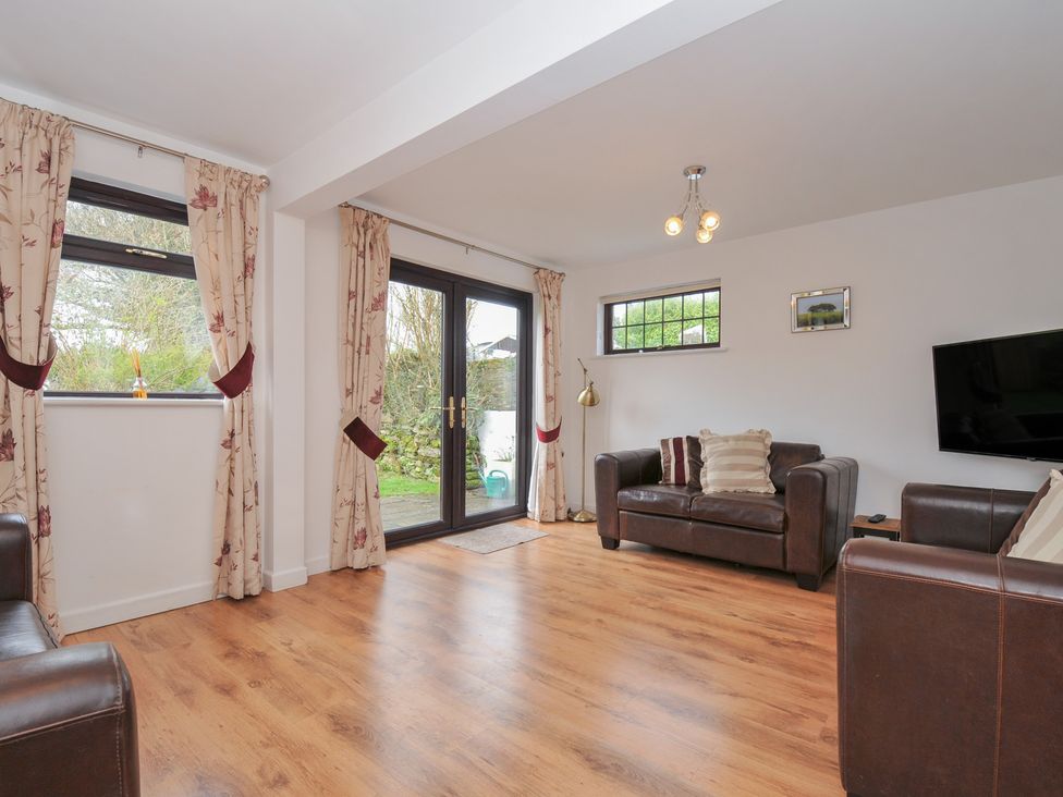 A living room with sofas and a television at Kernyk in Camelford