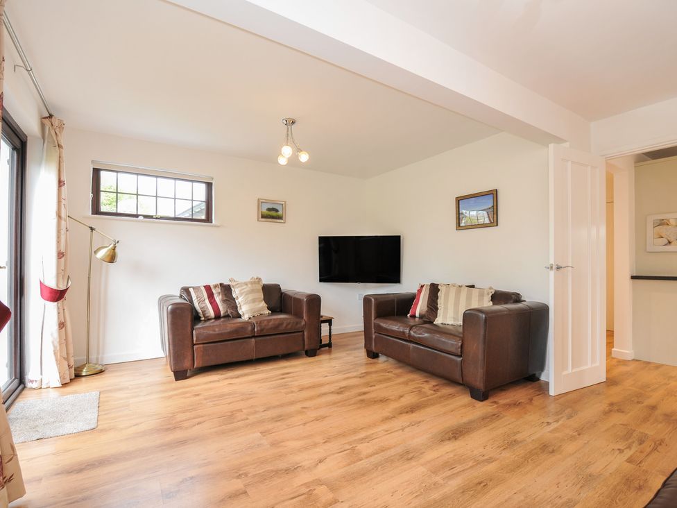 A living room with two sofas and a television at Kernyk in Camelford
