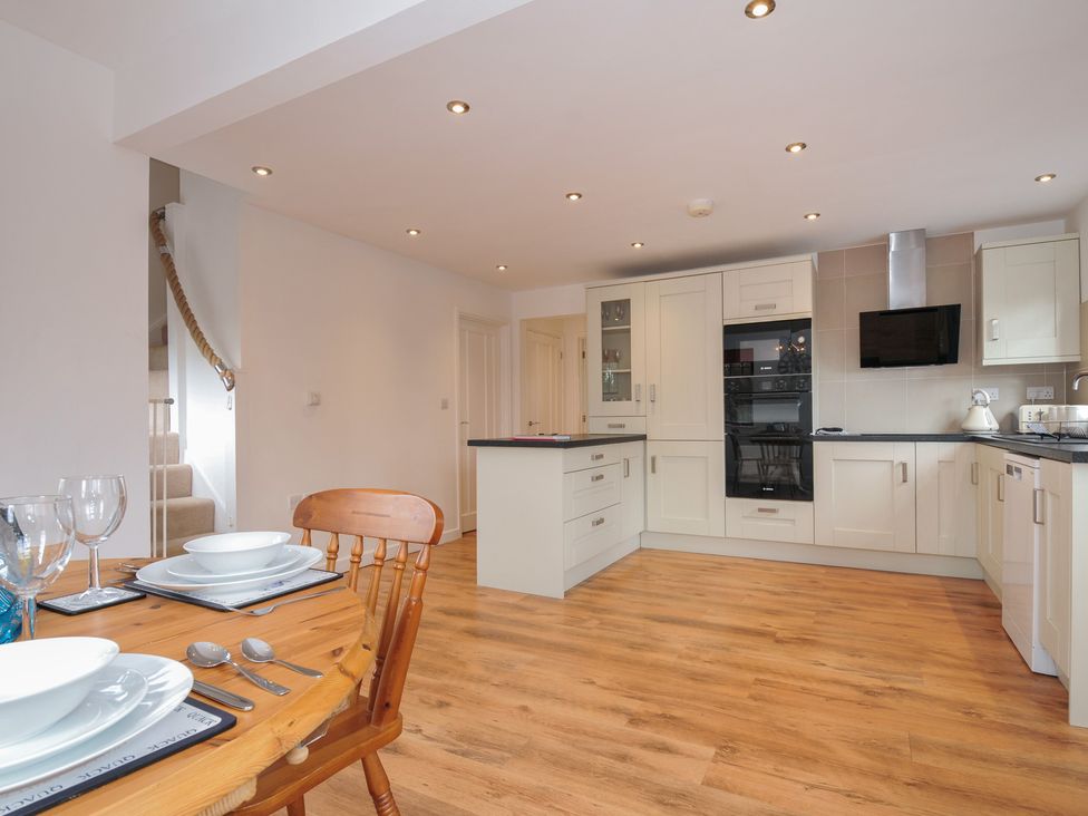 A kitchen with a dining table and chairs at Kernyk in Camelford