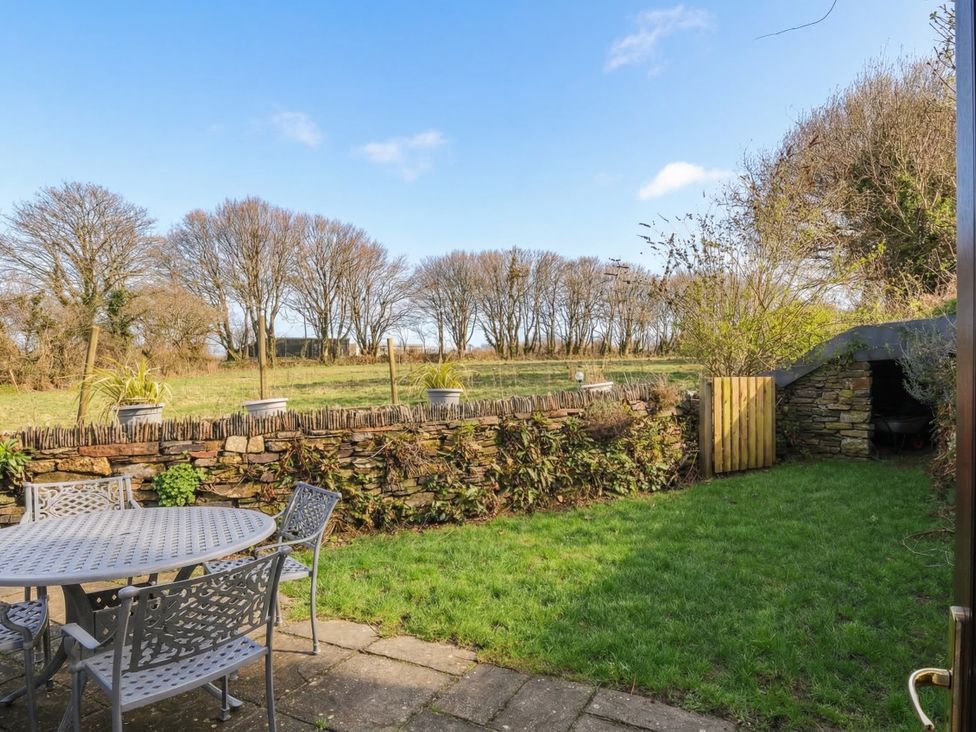 A garden with a table and chairs at Kernyk in Camelford