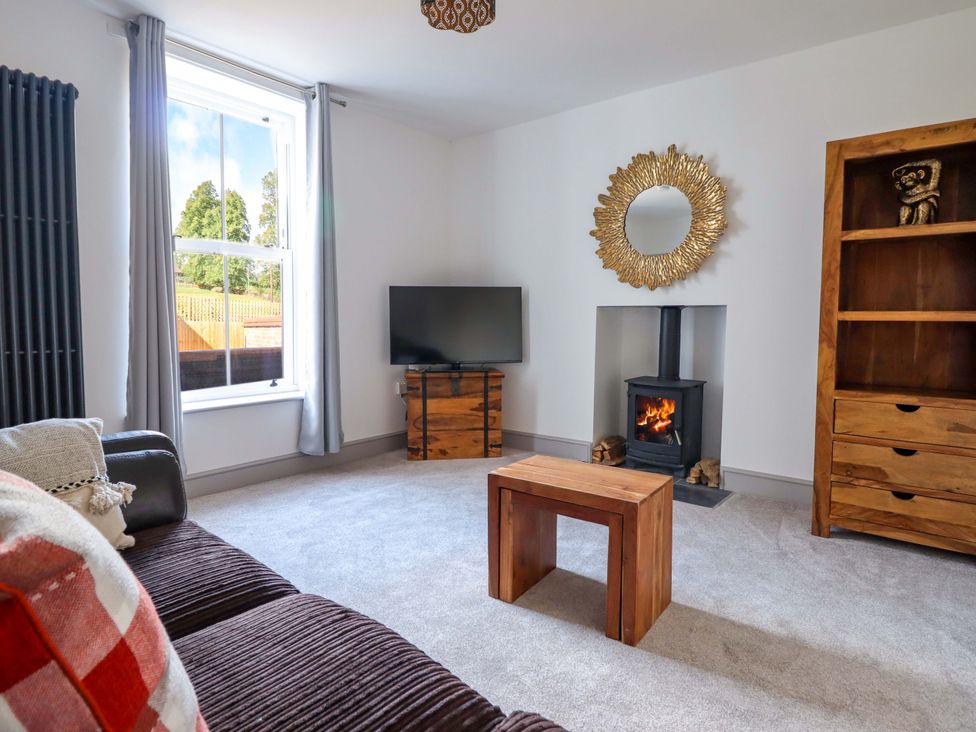 A living room with a television and a fireplace at The Farmhouse in Oswestry