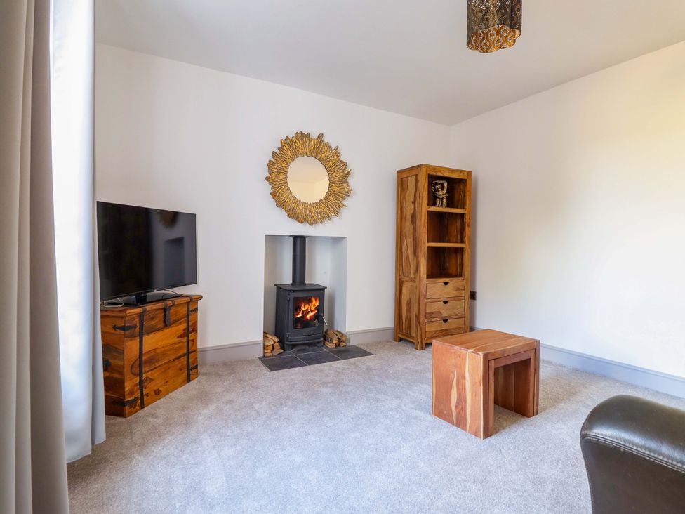A living room with a fireplace and television at The Farmhouse in Oswestry