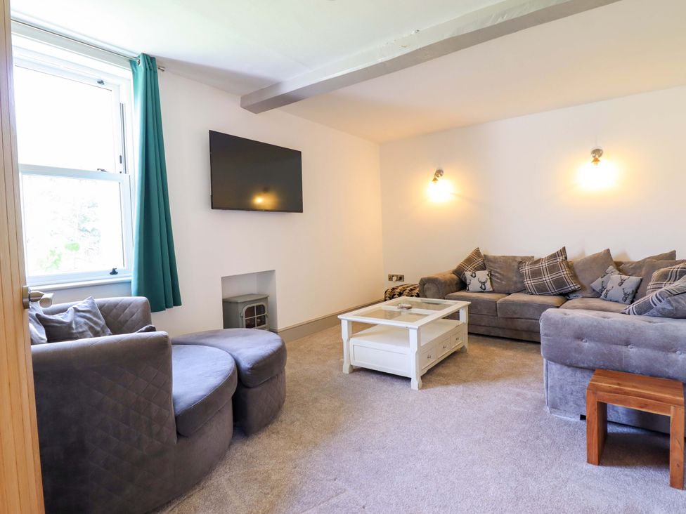 A living room with seating and a television at The Farmhouse in Oswestry