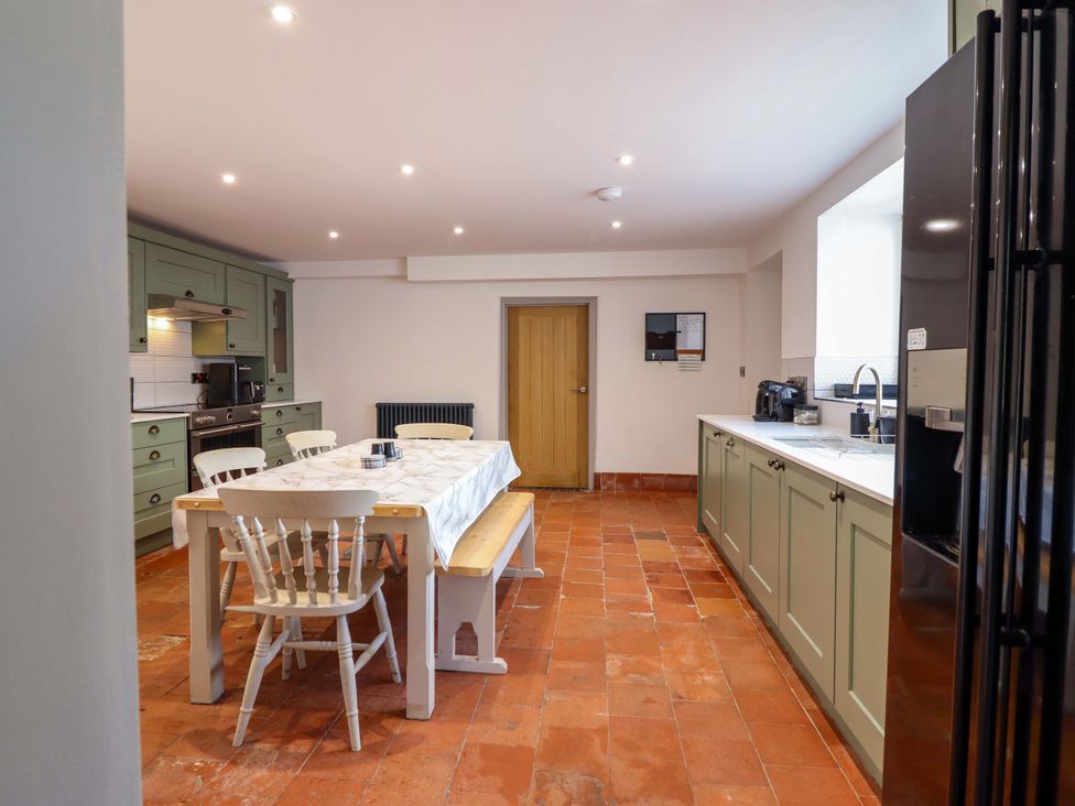 A kitchen with a dining table and chairs at The Farmhouse in Oswestry