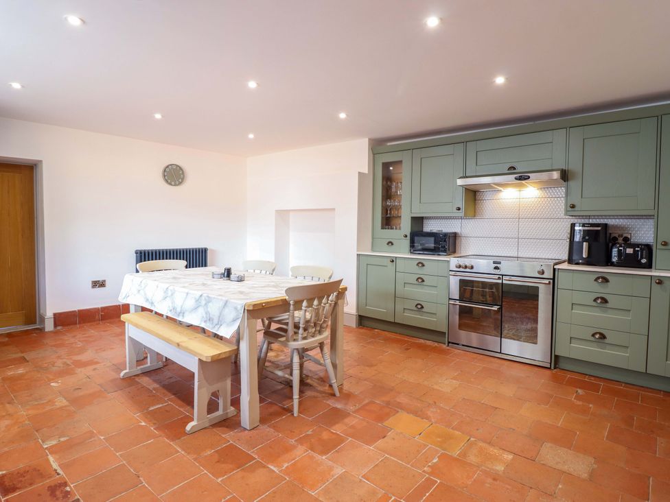 A kitchen with a table and chairs at The Farmhouse in Oswestry