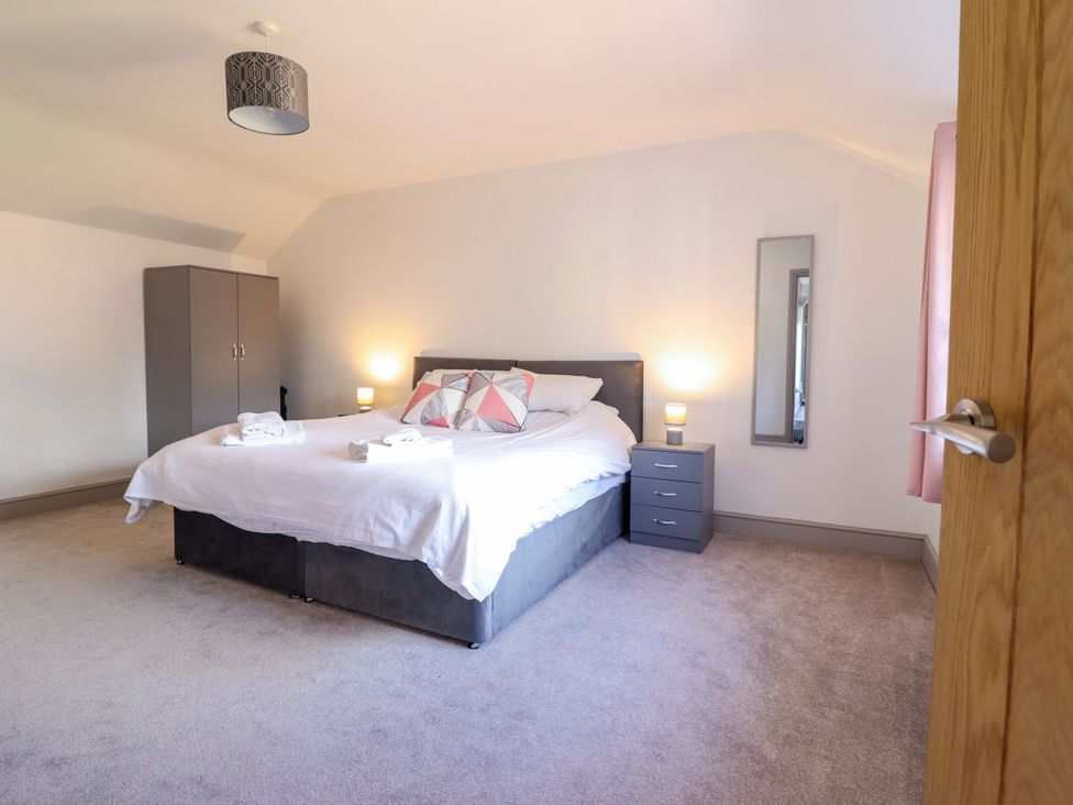 A bedroom with a bed and wardrobe at The Farmhouse in Oswestry