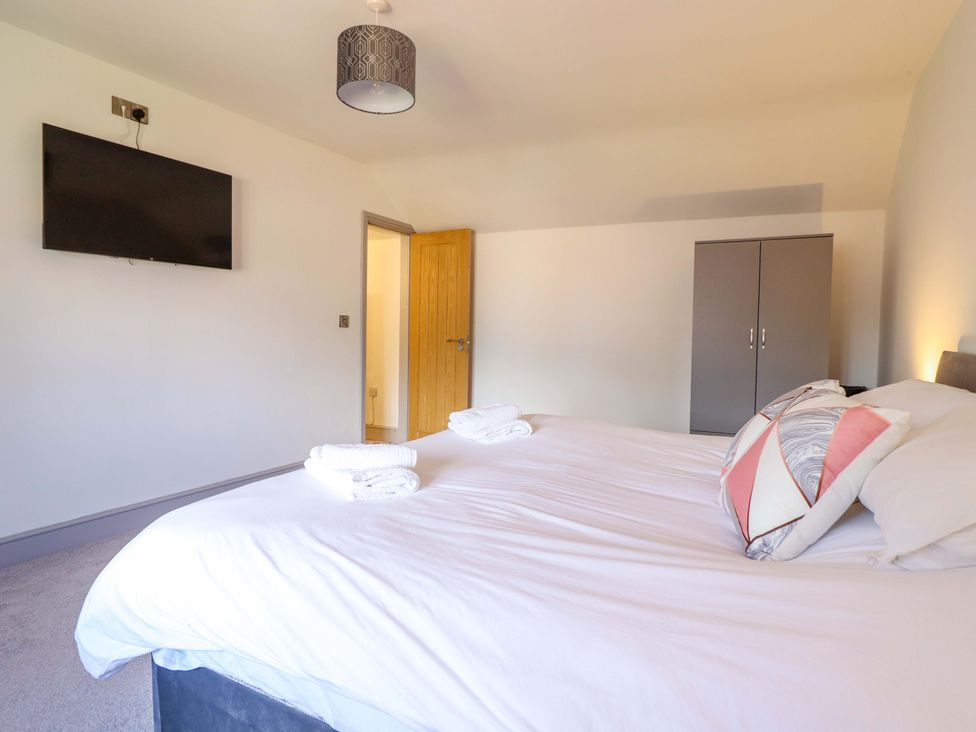 A bedroom with a bed and a television at The Farmhouse in Oswestry