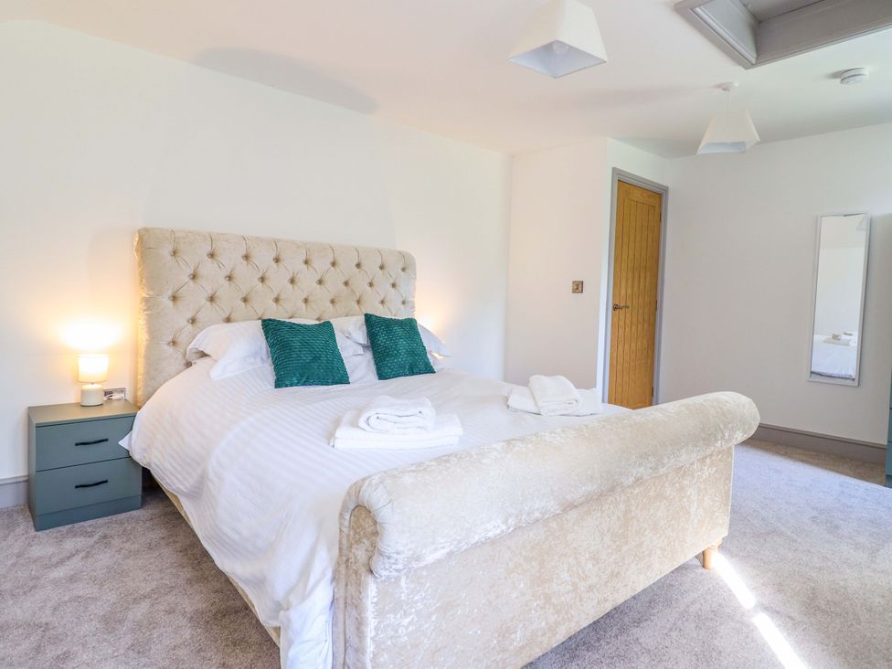 A bedroom with a bed and nightstand at The Farmhouse in Oswestry