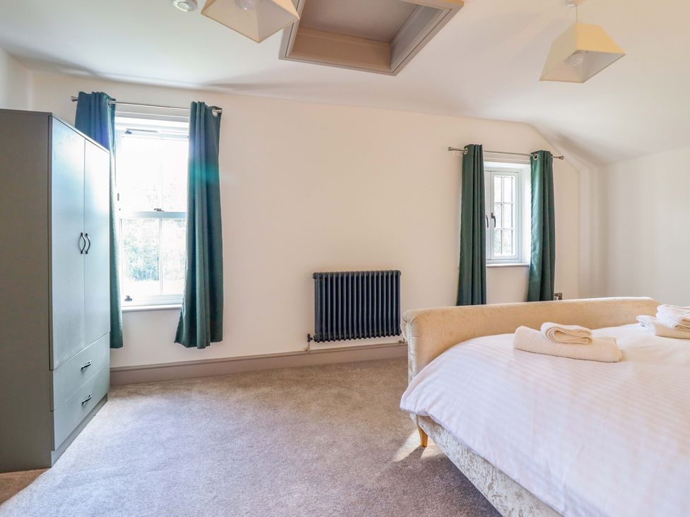 A bedroom with a bed and wardrobe at The Farmhouse in Oswestry