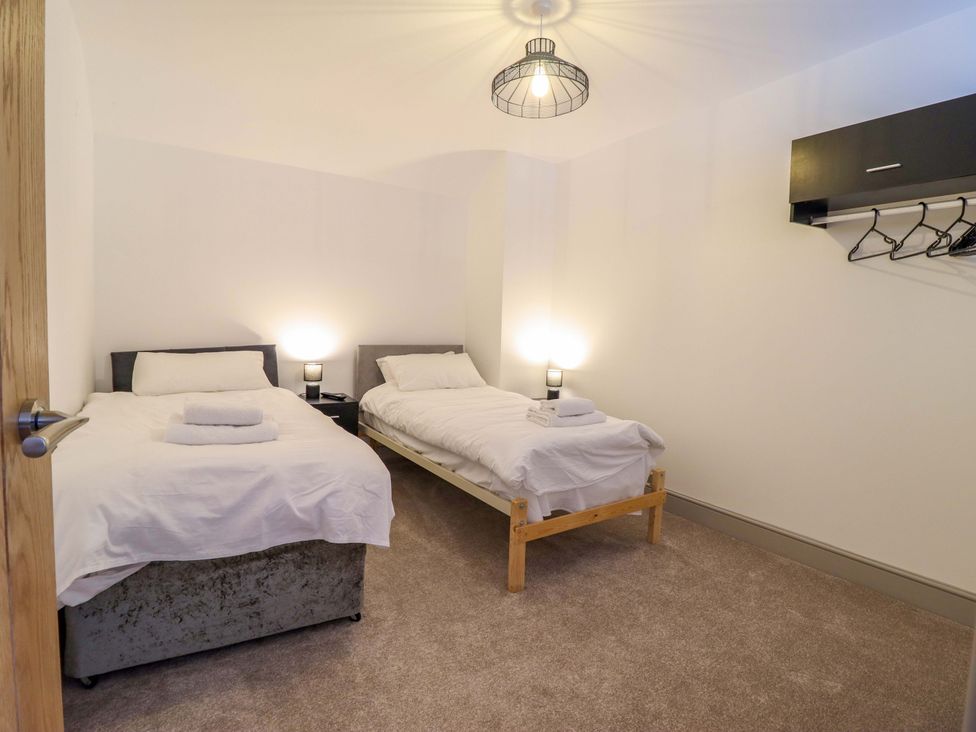 A bedroom with two beds and a lamp at The Farmhouse in Oswestry