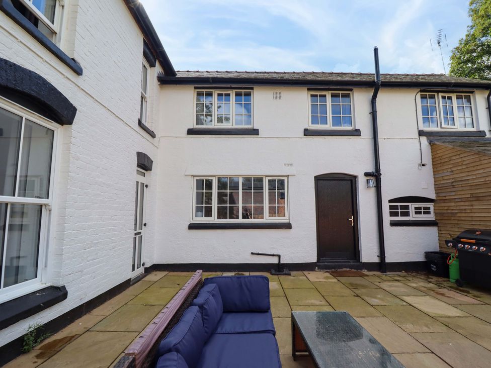 An outdoor area with a sofa, table, and door at The Farmhouse in Oswestry